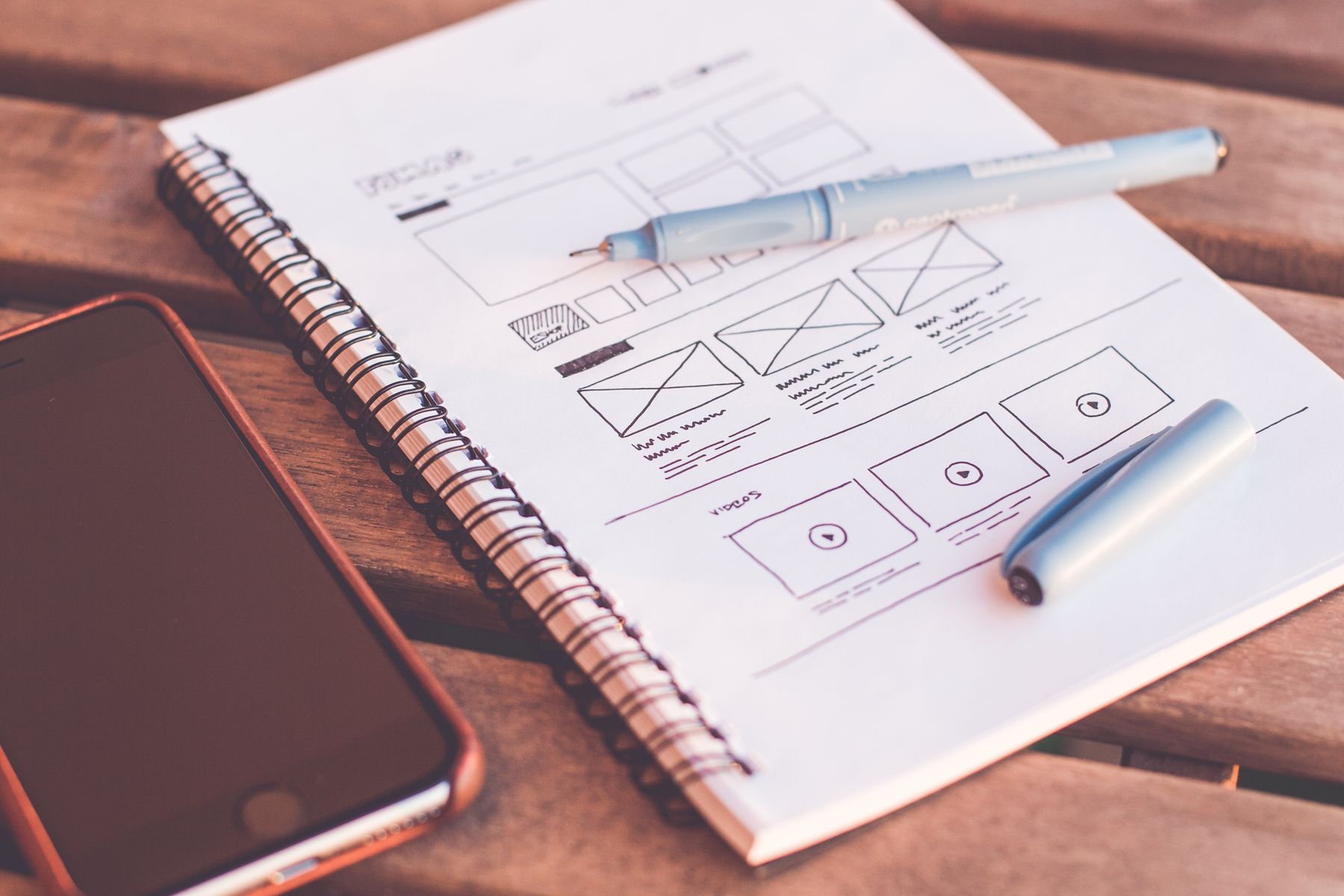 Printed layouts and design notes on a desk.